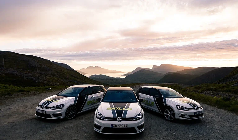 Biler på fjellvei med naturskjønn utsikt og solnedgang, robust media.