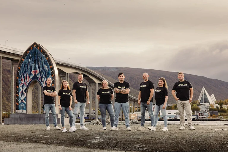 Robust team foran ikonisk kirke i Reykjavik, Island, med moderne bylandskap i bakgrunnen.